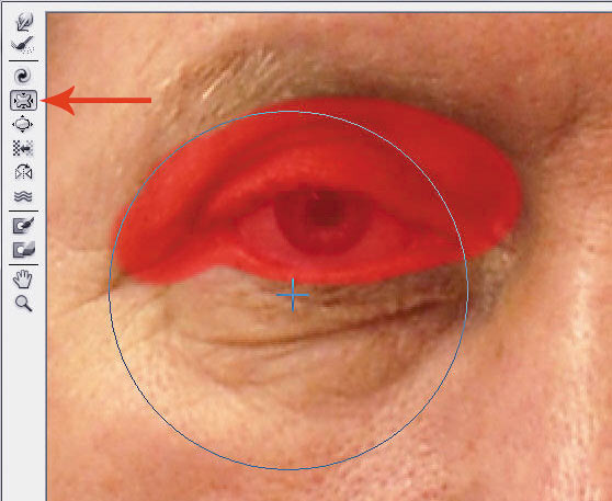 Рис. 23. Процесс коррекции портрета инструментом Сморщивание: а — уменьшение родинки; б — уменьшение мешков под глазами, защищенная область обозначена красным цветом